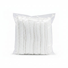 A clear plastic bag containing a stack of white textured cleaning or scrubbing pads, isolated on a white background.
