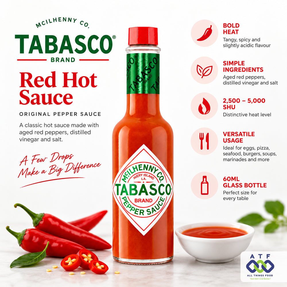 A bottle of McIlhenny Co. Tabasco Brand Red Hot Sauce centered, with red chili peppers, sliced chilies, and a small bowl of sauce used as styling props.