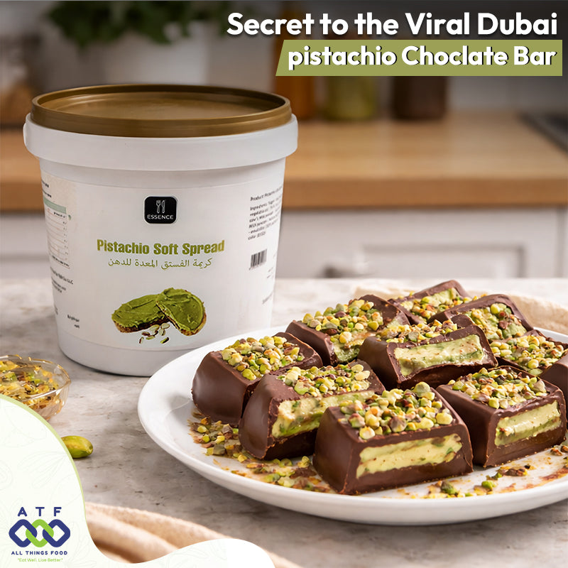 Pistachio chocolate bars on a plate with a container of pistachio soft spread in the background.