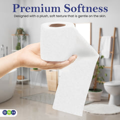 Hand holding a roll of white paper towel with 'Premium Softness' text in a bathroom setting.