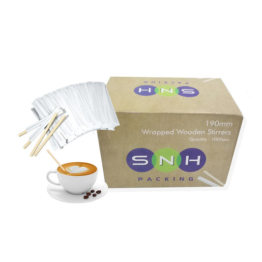 A box of SNH Packing wrapped wooden coffee stirrers, with some stirrers displayed in front of the box alongside a cup of coffee and a small wooden table.